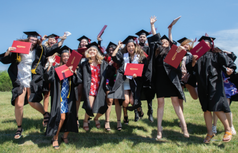 Photo of Gateway graduates, cheering while holding their diplomas
