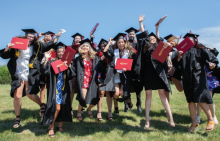 Photo of Gateway graduates, cheering while holding their diplomas