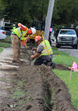 Three year-old photo of crews installing cable in a city parkway. 