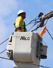 File photo of lineman in the air in a bucket. 
